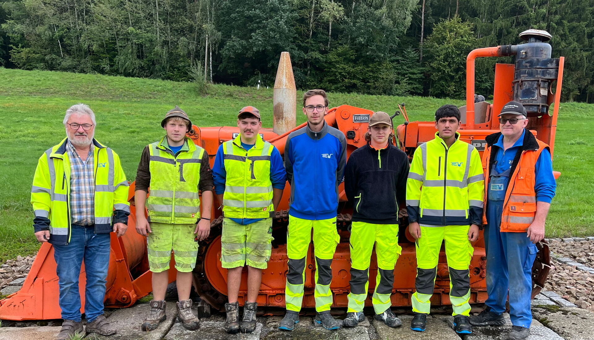 Gruppenbild mit Lehrlingen vor einer Maschine