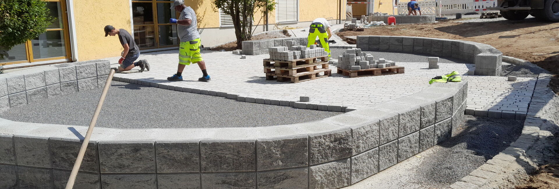 Arbeiter beim Pflastern einer Terrasse